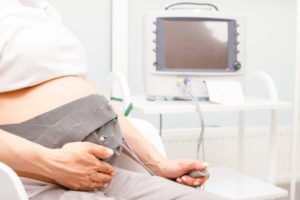 A pregnant woman sat in a hospital attached to a baby monitoring machine.