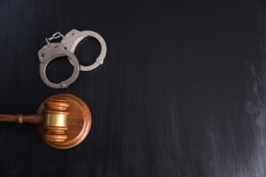 A gavel and a pair of handcuffs on a table