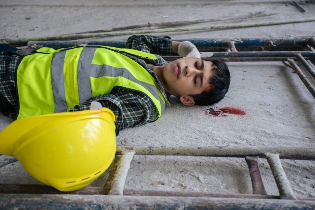 a man who has suffered a serious injury in an accident at work lying on the ground