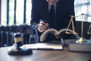 No win no fee personal injury compensation solicitor sitting at his desk writing in a ledger.