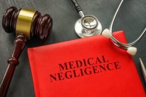 A red document with the words 'medical negligence' next to a gavel and stethoscope