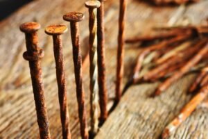 Some rusty nails sticking out of some floorboards.