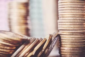 Stacks of coins, with one falling down