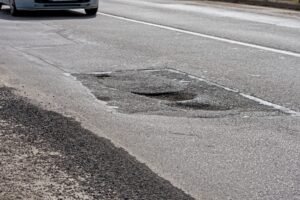 A deep pothole or road defect shown as a potential hazard for all motorists
