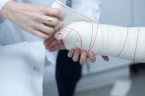 A doctor applies a cast and bandages to a patient's arm with nerve damage