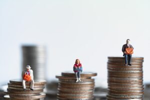 people sit on piles of coins for our guide on 'is compensation taxable?'