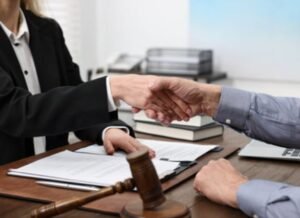 A criminal injury claim solicitor and a client sat at a desk and shaking hands