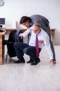 A man helps someone up off the floor.