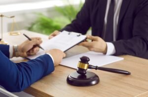 A surviving spouse fills in a form while their solicitor explains how to claim for a Bereavement Award.