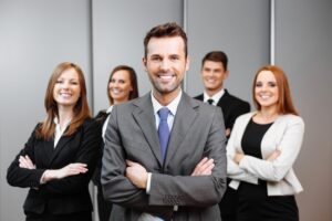 A team of lawyers stand smiling with their arms folded, ready to fight for domestic abuse compensation.