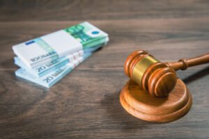 A stack of notes and a gavel on a table to represent criminal injuries compensation.