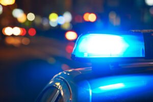 Blue lights on a police car at the scene of a criminal injury at night, representing our guide on Criminal Injuries Compensation