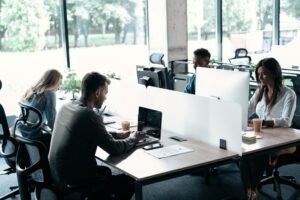 Employees sit at their office desks whilst working on their computers.