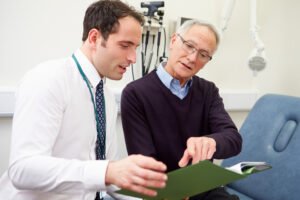 A GP explains the symptoms of testicular cancer to a patient after they undergo an ultrasound scan.