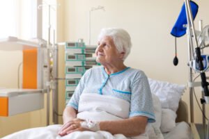 A vulnerable patient sits in a hospital bed.