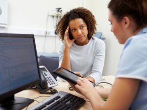 A woman talks to a nurse about the early stages of cancer.