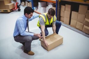 An employer supervises a worker lifts boxes correctly to avoid tendon damage.