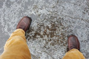 Man's feet on top of an ice path on the floor