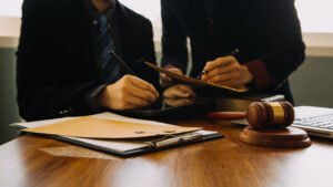 Two playground accident claims solicitors sat with legal documents on a table with a gavel.