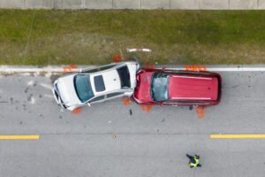 A birds-eye view of a rear-end collision between a red and silver car.