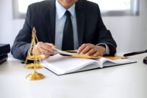 A claims against the council specialist solicitor sat at a desk with a set of judgement scales.