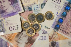 A pile of bank notes and pound coins. 