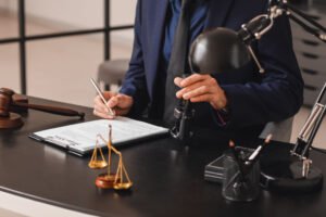 A wrongful death solicitor sat on a desk with documents, justice scales, and gavel. 