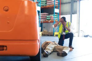 A worker in hi-vis uses their phone for their colleague after a workplace motor vehicle accident