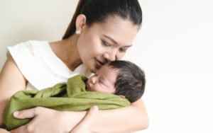  A mother holding her baby after experiencing birth trauma due to the failure of a medical provider to give adequate treatment