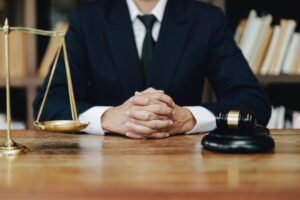 A solicitor sits behind a wooden desk whilst discussing slip and fall at work compensation