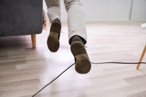 Close up of a man tripping over a trailing wire.