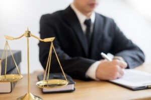 One of the motorcycle accident lawyers working on a claim at a desk with scales and law book. 