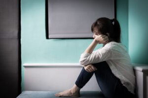 A sad woman sat on a mat after contraceptive negligence. 