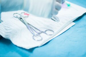 Surgical tools laid out on white cloth on a table.