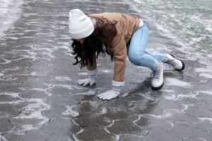 A woman slipping and tripping on an icy pavement