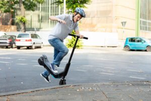 An e-scooter rider crashing onto a kerb and falling off