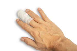 A man's finger wrapped in a bandage after an injury.
