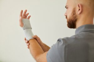 A man wearing a bandage on his wrist after sustaining a hairline fracture 