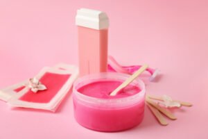Waxing products set against a pink background.