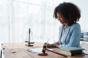 A bike accident lawyer working on a claim at a desk with scales and a gavel. 