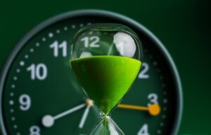 Green hourglass in front of a clock showing the limitation period.