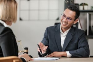 A solicitor for hip injury claims discussing compensation across a table with a gavel on it.