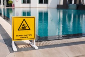 Wet floor sign next to swimming pool