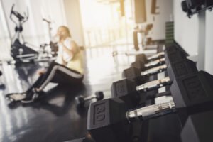 A woman is drinking water in the gym 