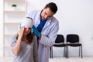 A woman getting her head injury checked by a doctor 