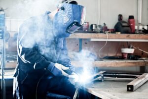 A worker wearing a mask while using welding equipment.